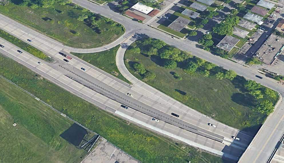 An aerial view of on- and off- ramps between frontage roads and the highway.