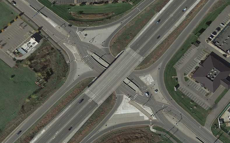 Aerial view of an intersection where drivers cross lanes to reduce turn movements.