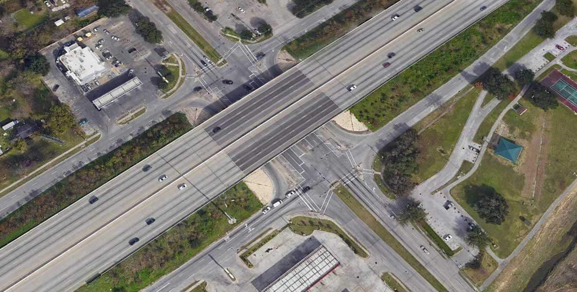 Aerial view of a U-turn underneath a highway overpass.